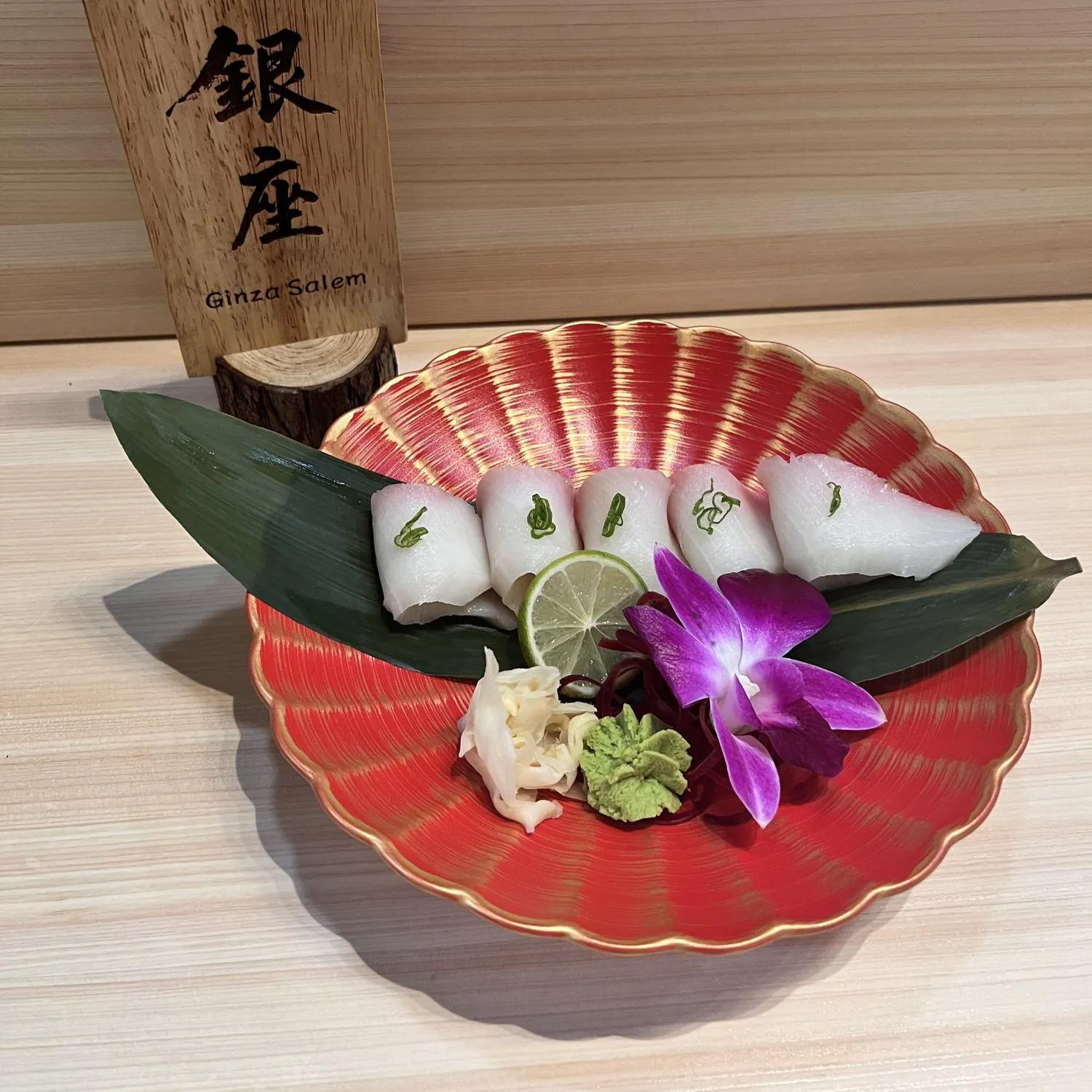 White fish nigiri with green garnish, served with lime and wasabi at Ginza Sushi and Ramen, a Japanese Restaurant in Salem