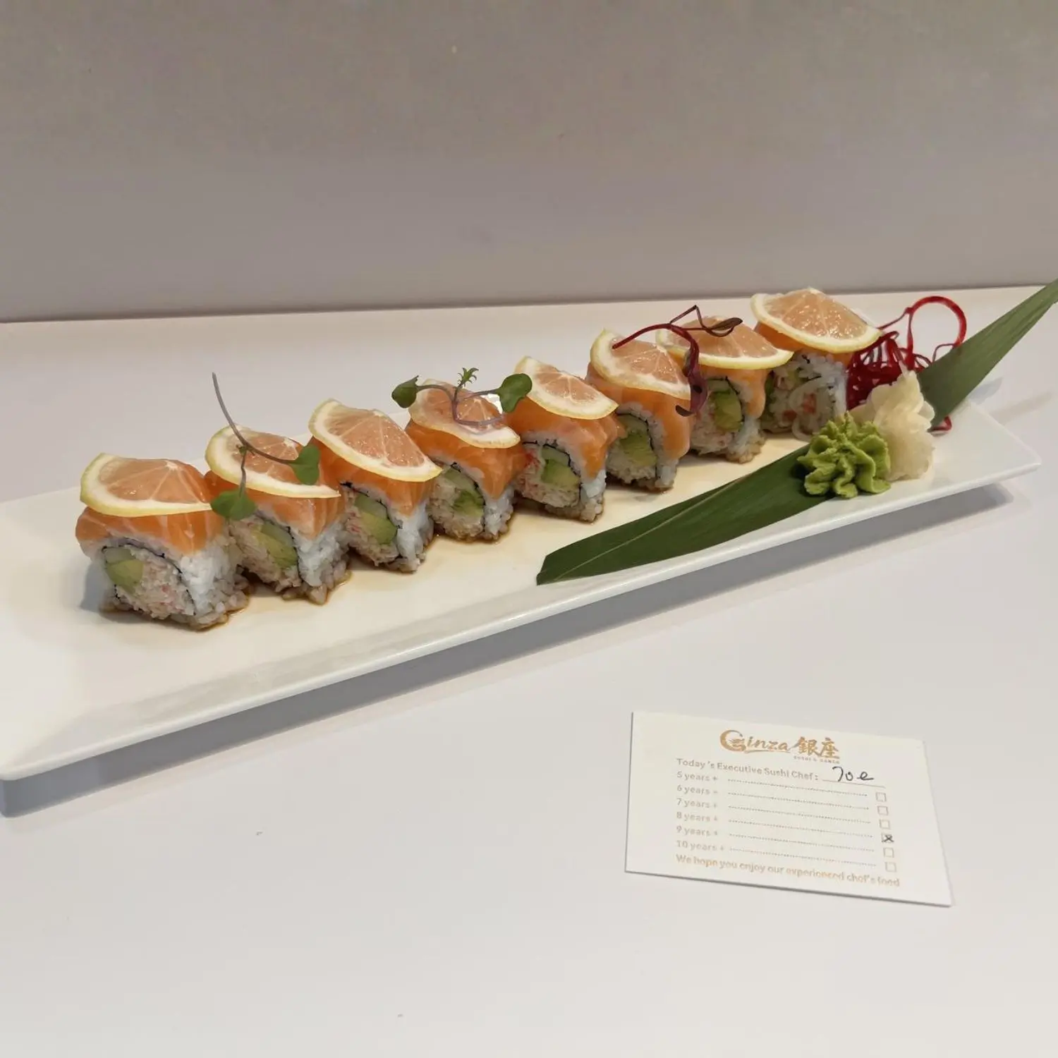 Sushi roll with salmon and avocado, topped with lemon slices at Ginza Sushi and Ramen, a Japanese Restaurant in Salem